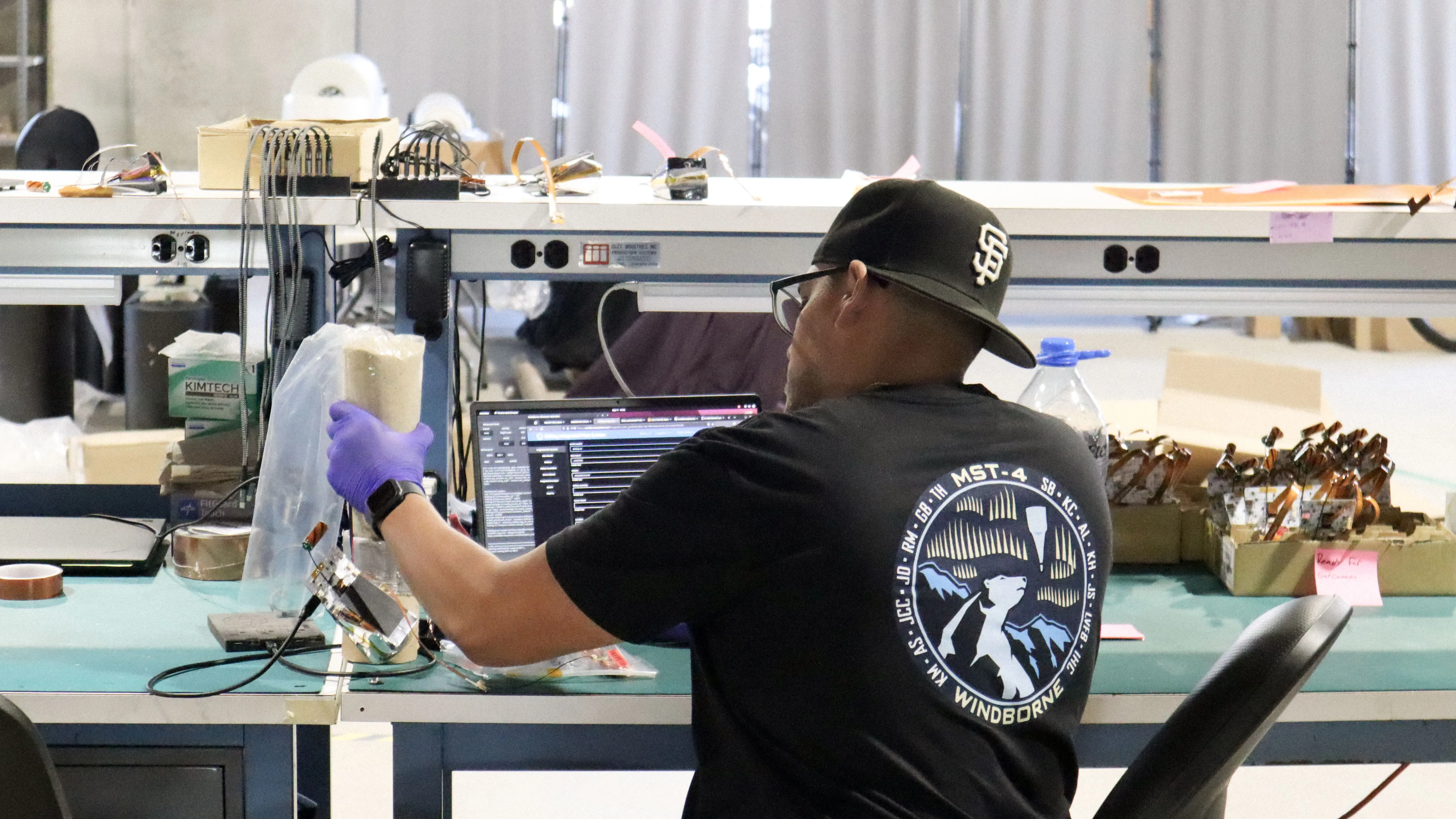 A WindBorne technician working on balloon hardware in the manufacturing facility
