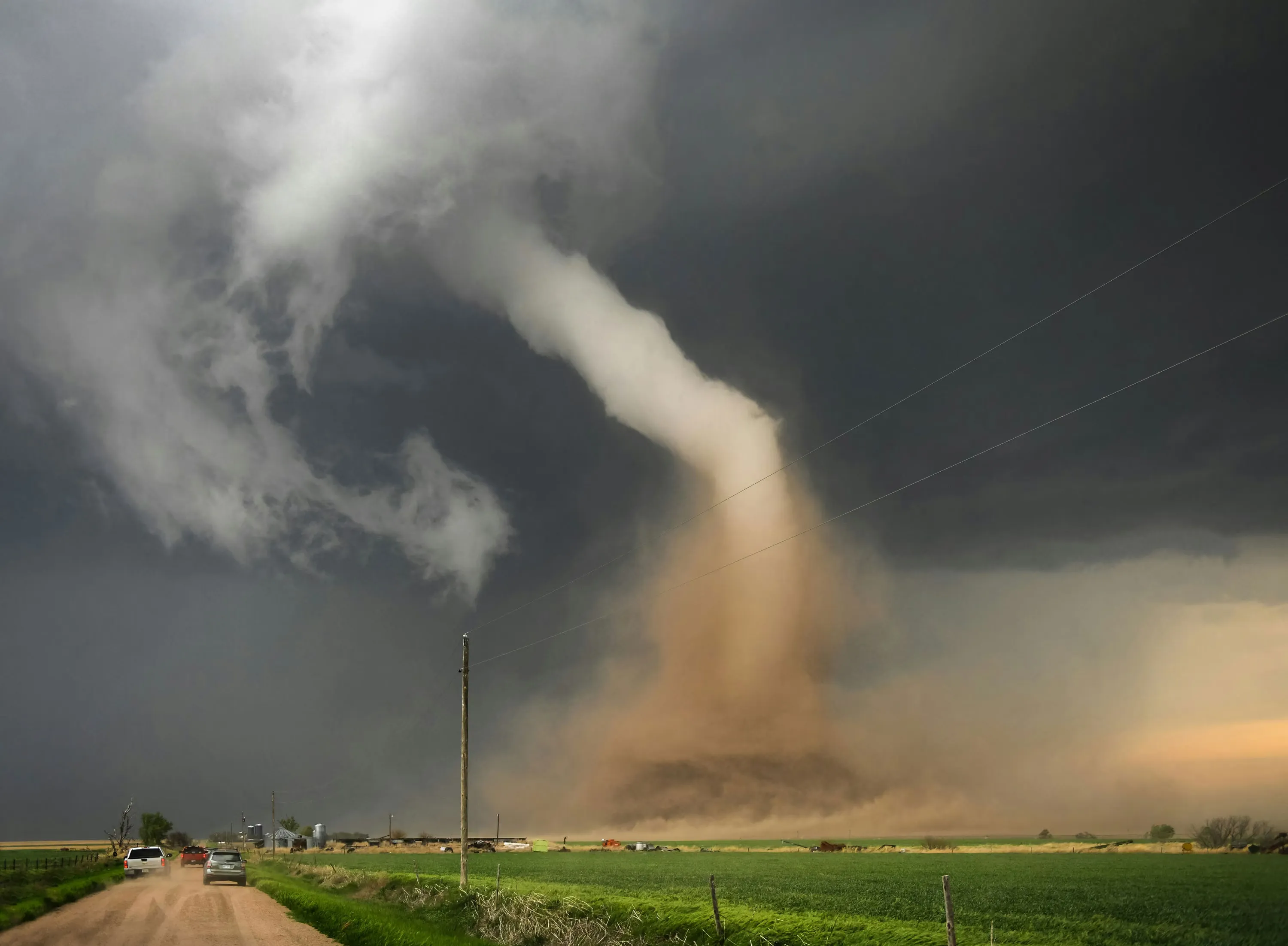 A tornado beneath a dark supercell thunderstorm